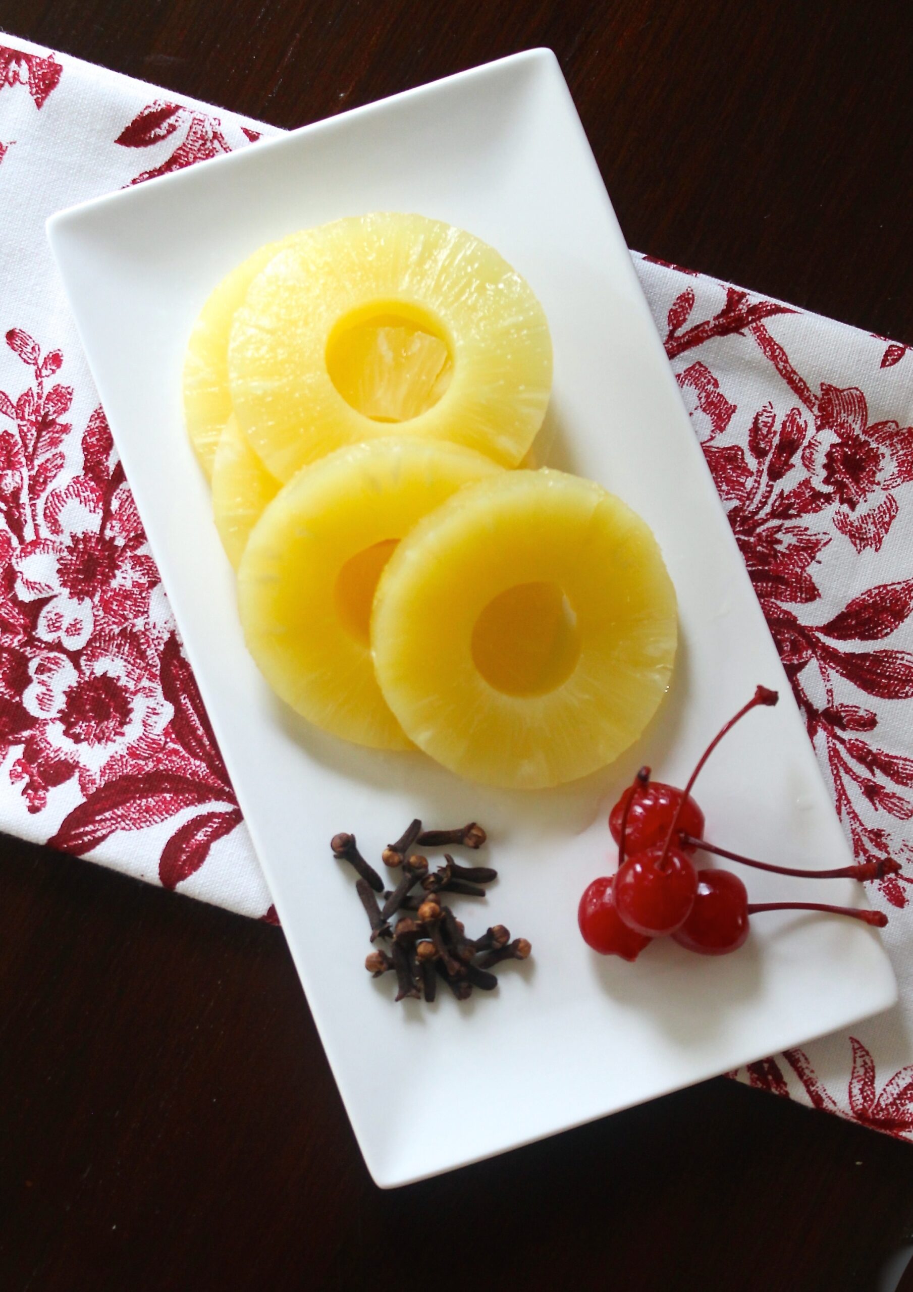 ingredients to roast a ham with pineapple, maraschino cherries and cloves.