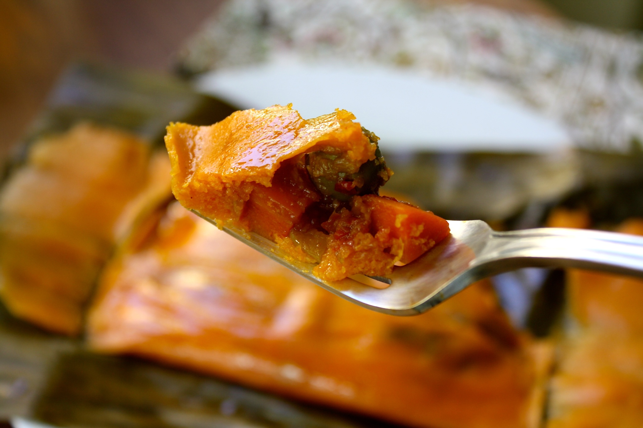 A fork with a piece of vgetarian hallaca.