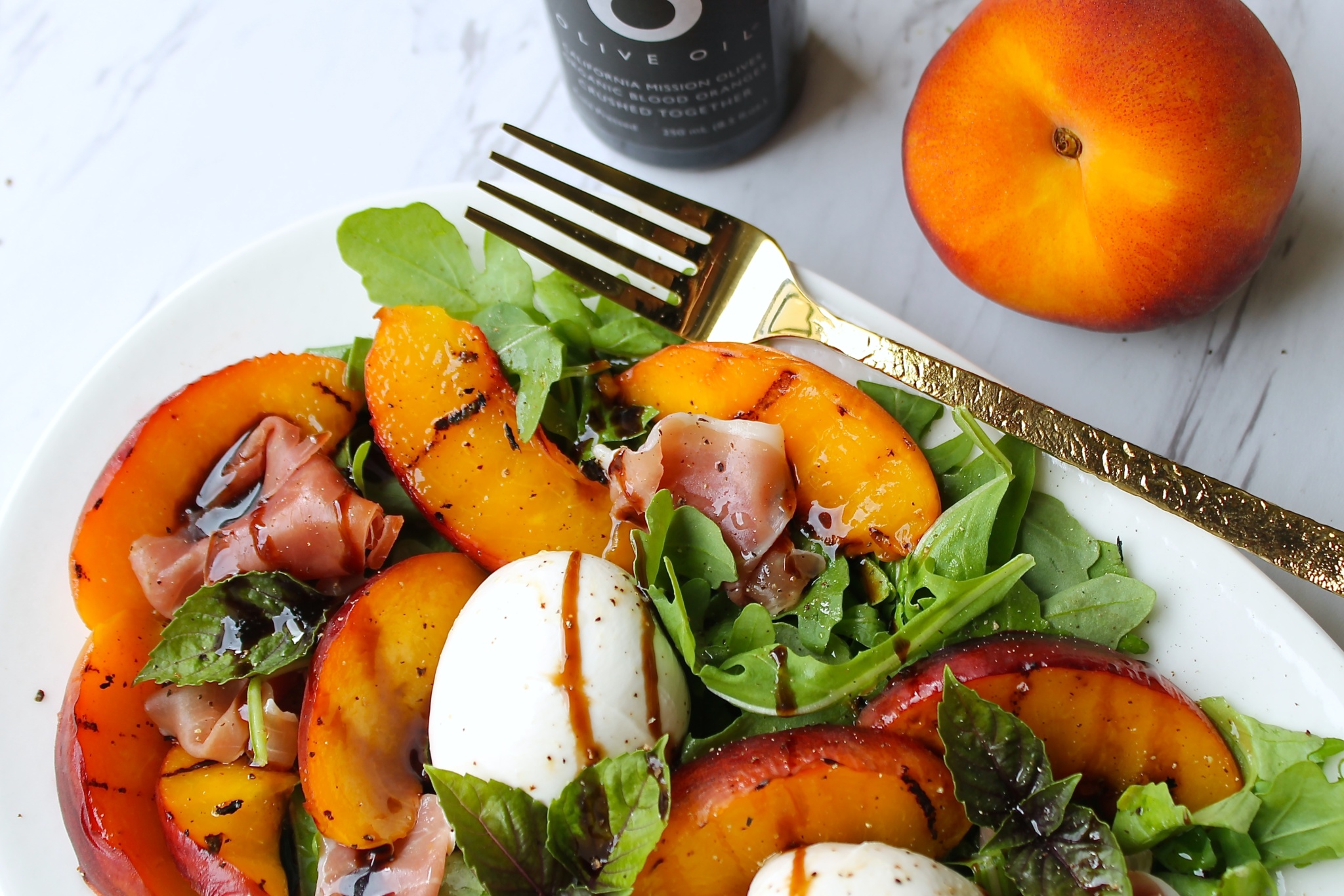 ensalada de arugula con melocotones asados, prosciutto y burrata