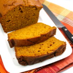 A slice of pumpkin-spice bread with orange zest on a plate.