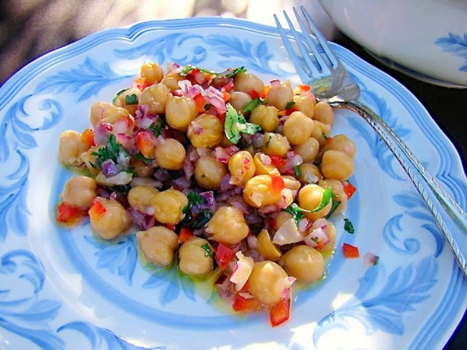 primer plano de ensalada de garbanzos servida en plato de porcelana azul