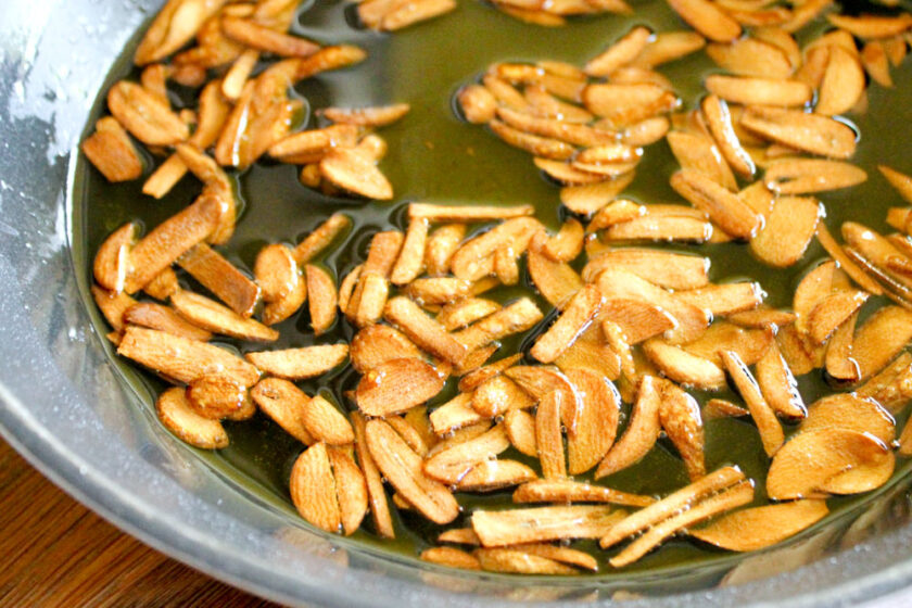Garlic slices simmering in a pan with olive oil