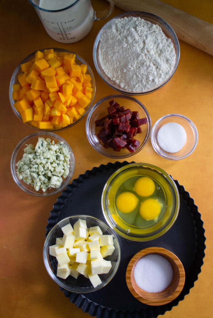 Vista cenital de los ingredientes para hacer quiche de calabaza con gorgonzola y guayaba