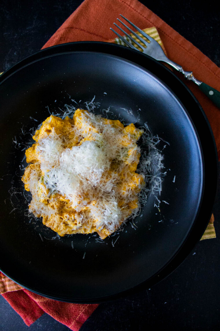 Un plato de pasta con queso parmesano.