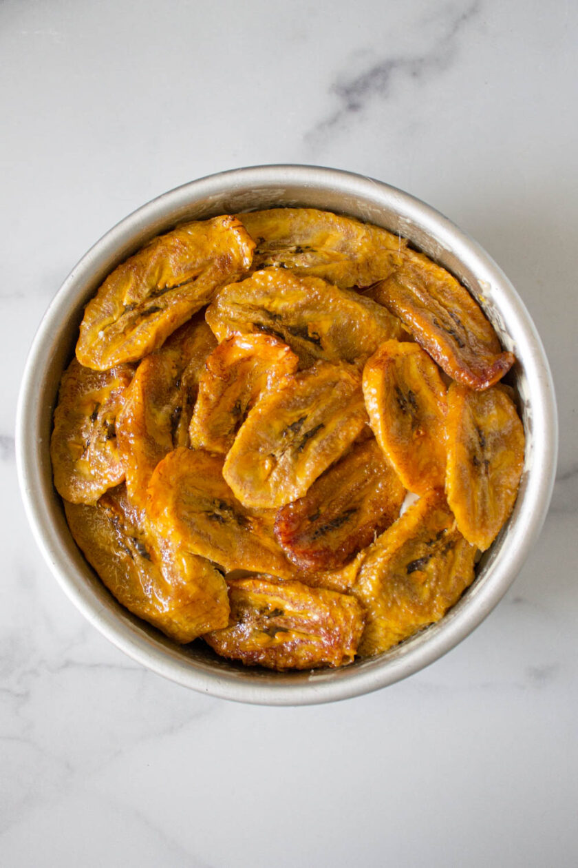 Cenital view a plantain and cheese casserole, aka torta de plátano venezolana, in a cake pan.
