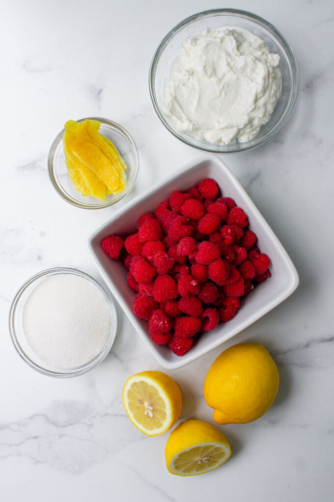 Ingredientes para hacer popsicles de yogurt con frambuesas y limón.