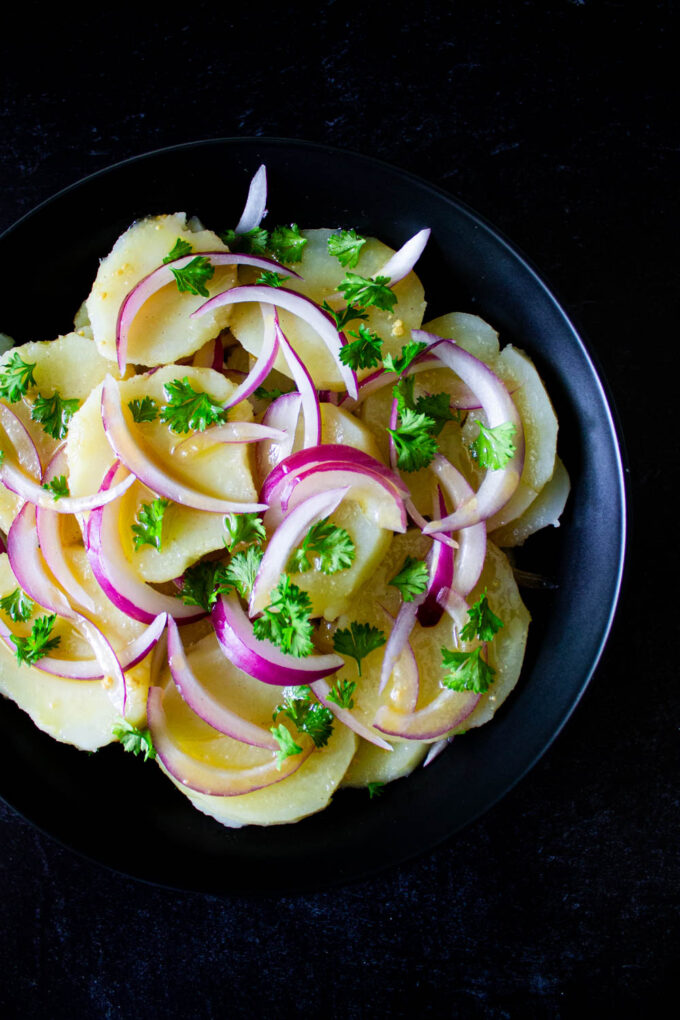 Venezuelan potato salad served on a black plate, by enrilemoine.