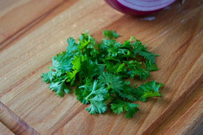 Curly parsley on a wooden board, by enrilemoine.