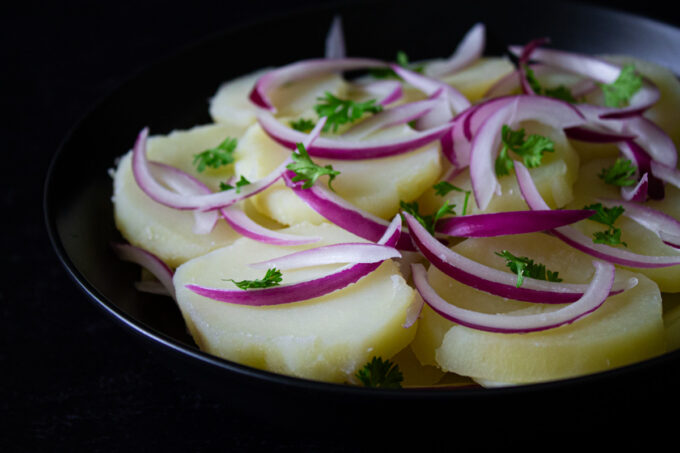 Venezuelan potato salad in a black bowl.