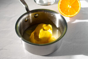 Jarabe de limón en una olla, con pieles de limón.