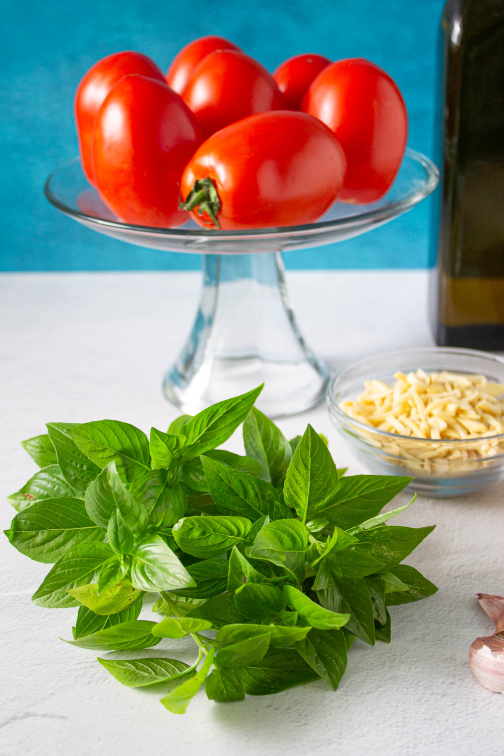Alguno de los ingredientes para hacer pesto siciliano: albaca, tomates, almendras y aceite de oliva, by enrilemoine