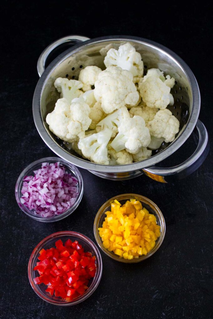 Ingredientes to make Venezuelan cauliflower salad : cauliflower florets and finely chopped yellow and red bell peppers as well as red onion, byenrilemoine .