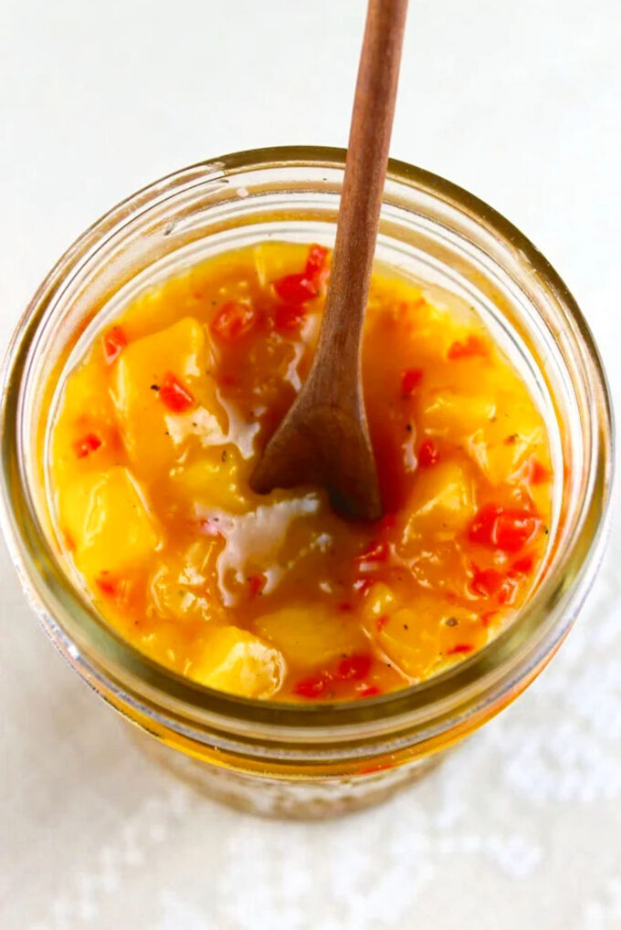 Close up of a Venezuelan mango chutney in a glass jar.