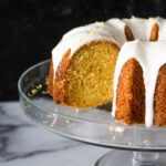 A Meyer lemon pound cake with a glazed icing, presented on a glass plate.