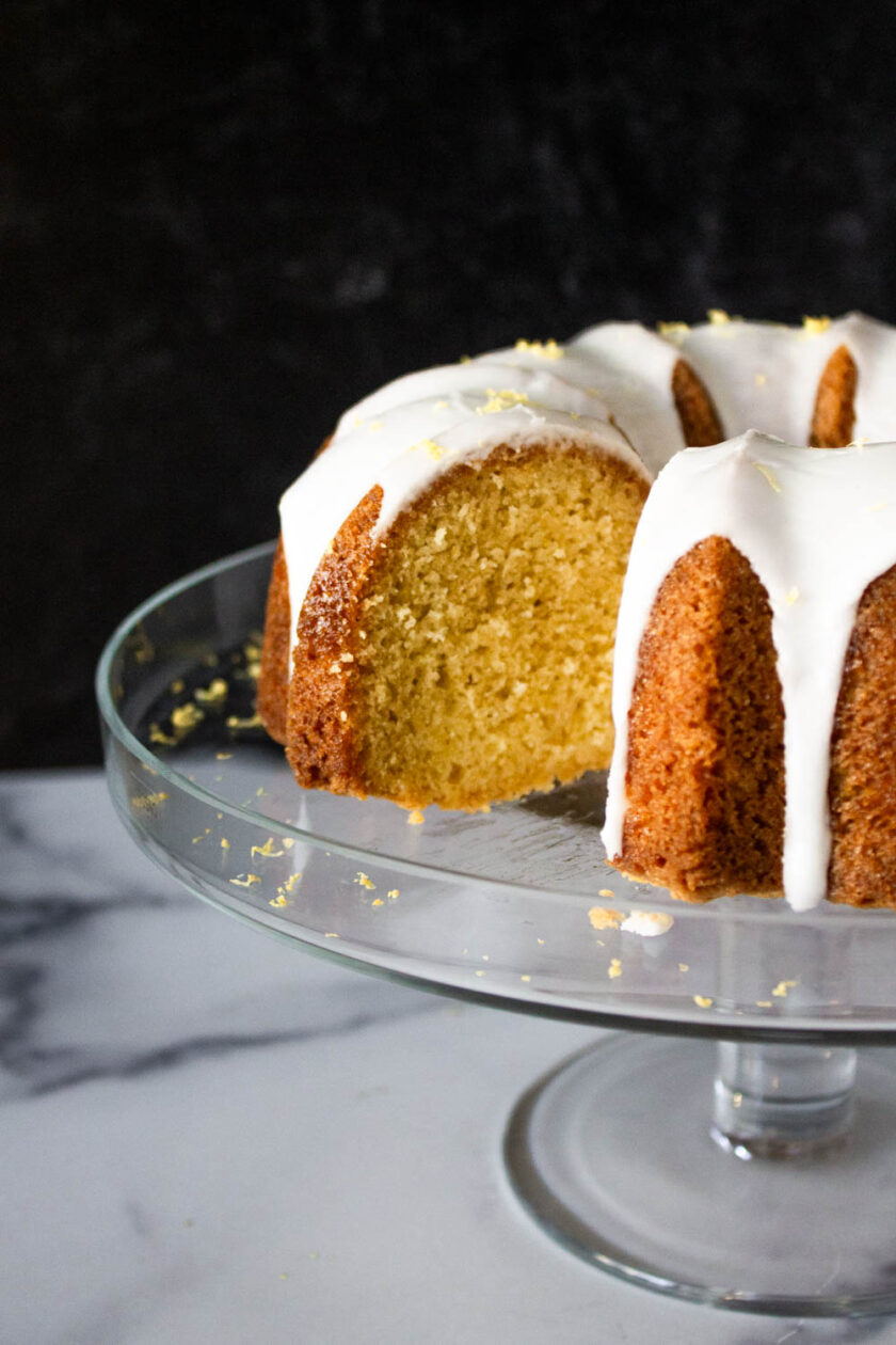 A Meyer lemon pound cake with a glazed icing, presented on a glass plate.
