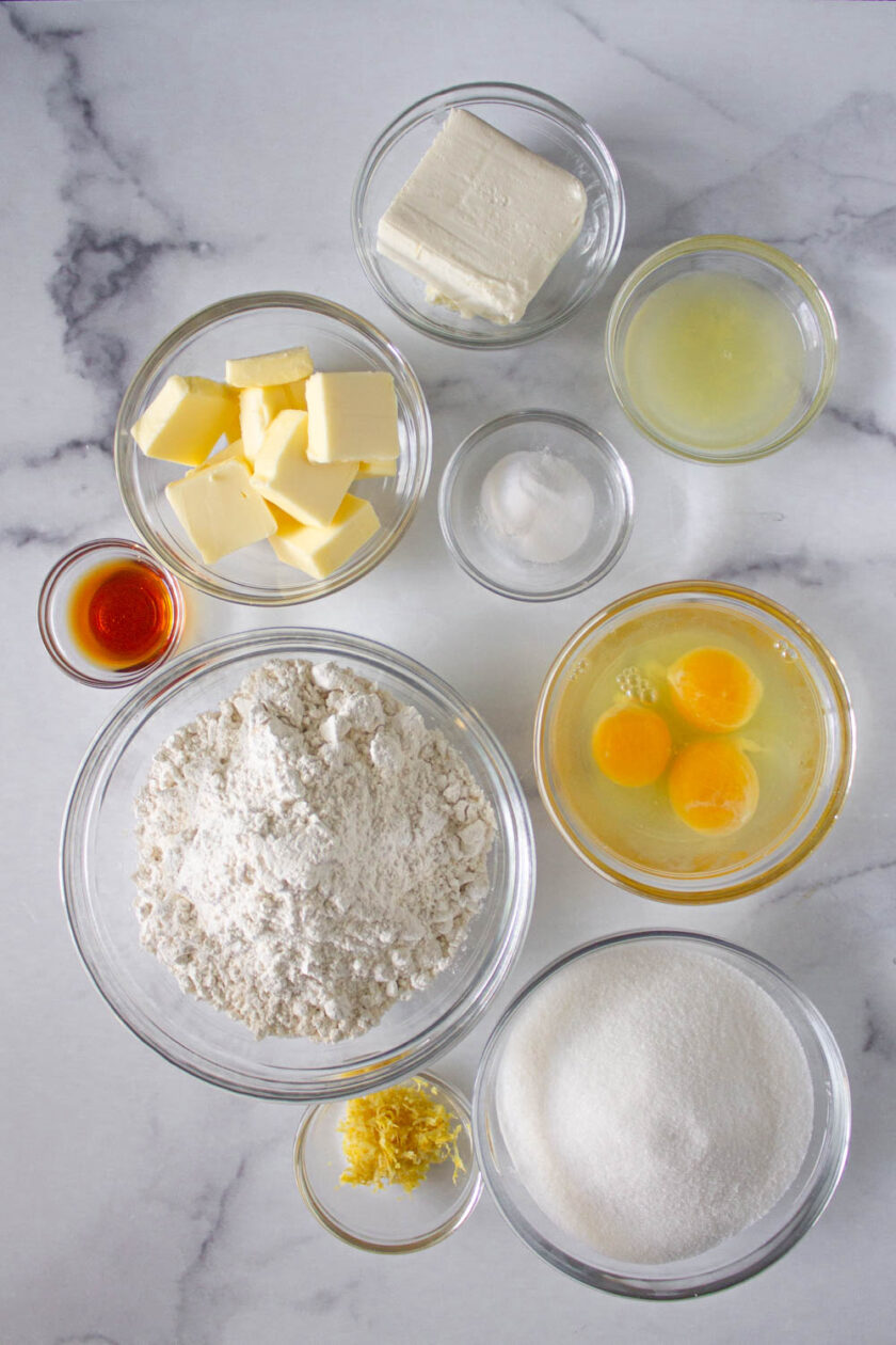 Lemon pound cake recipe displays ingredients in bowls on a marble table, by enrilemoine.