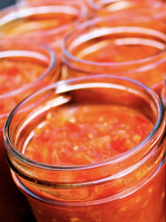Jars of tomato sauce sitting on a table, Venezuelan tomato & onion sofrito.