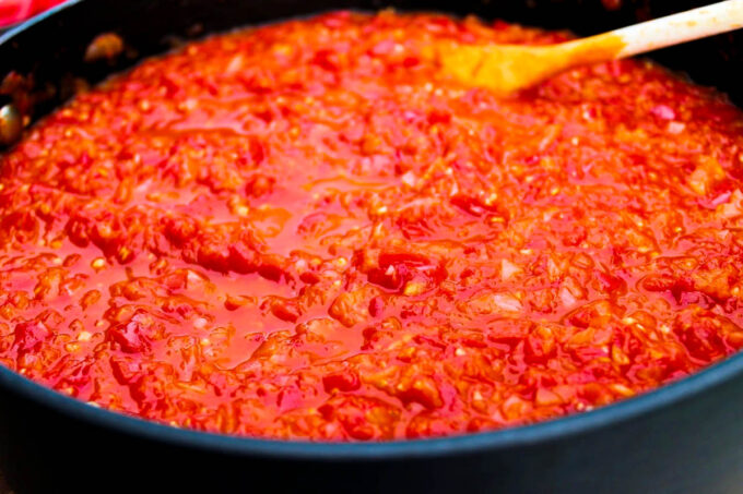 Sofrito de tomate en una sartén con una cuchara de madera by enrilemoine.