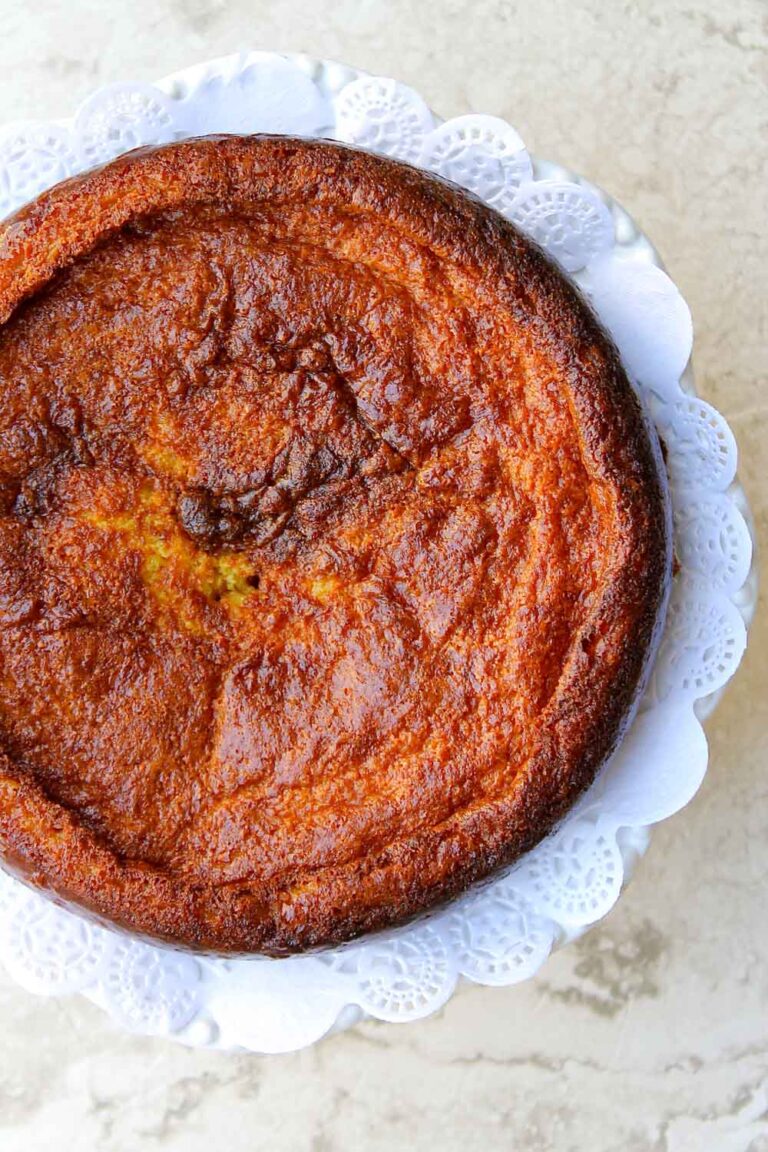 Una torta de jojoto está sobre un plato blanco sobre una mesa.
