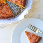 Una rebanada de torta de jojoto en un plato con un tenedor.