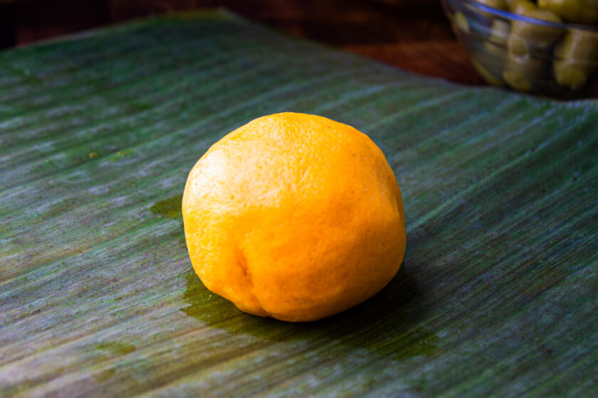 A ball of hallaca dough on a plantain leave, by enrilemoine.