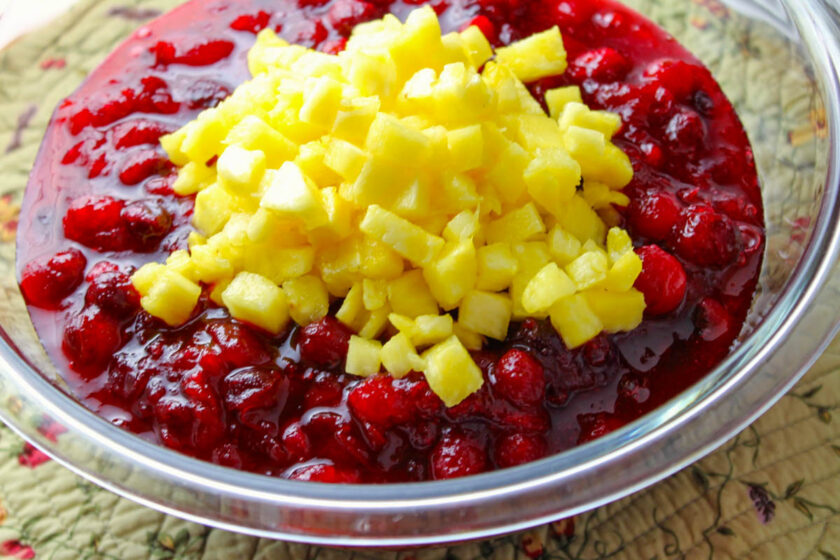 A glass bowl with cranberry sauce and diced pineapple.