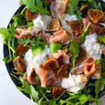 Ensalada de higos, queso burrata, prosciutto y rúcula.
