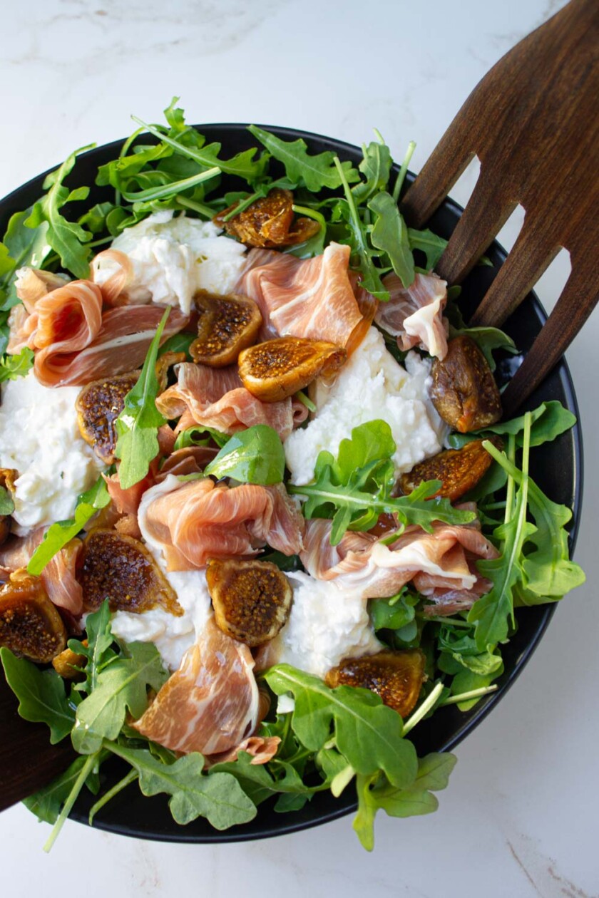 Ensalada de higos, queso burrata, prosciutto y rúcula.