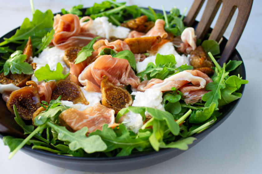 Ensalada de higos, queso burrata, prosciutto y rúcula.