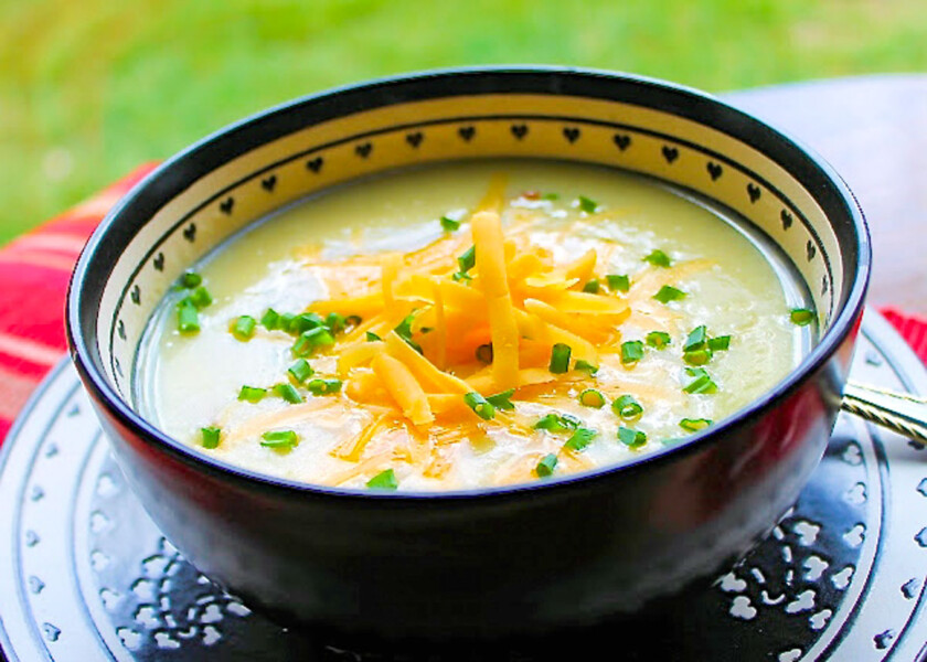 A warm and cozy bowl of creamy potato soup with cheese on top.