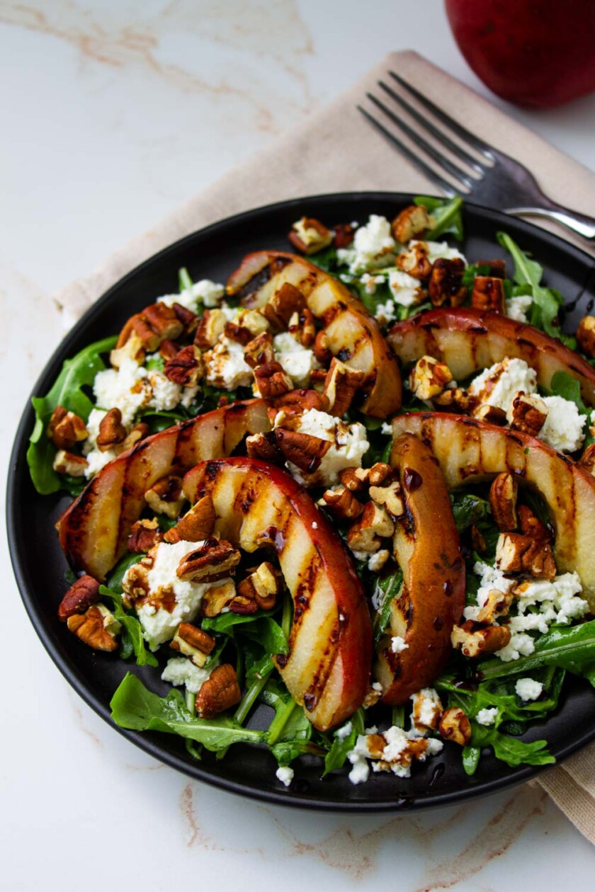 A plate of grilled pearsand arugula salad.