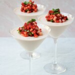 Three martini glasses with strawberry panna cotta.