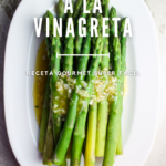 Espárragos cocidos con vinagreta en un plato ovalado blanco.