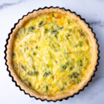 Freshly baked quiche on a marble surface.