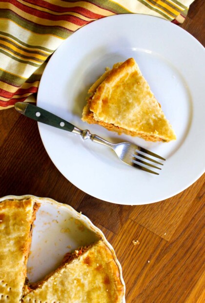 Un plato con un trozo de polvorosa de pollo y un tenedor encima.