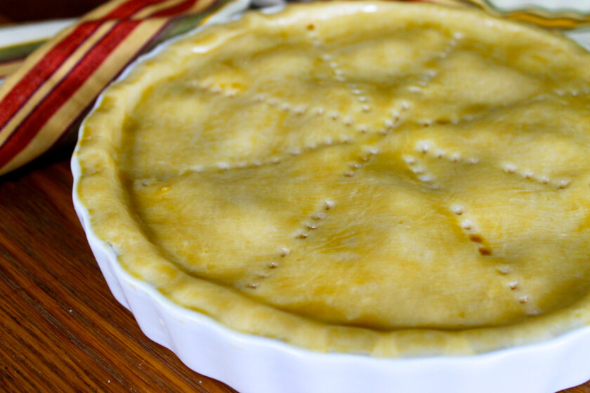 Un pastel de pollo barnizado con huevo, antes de entrar al horno.