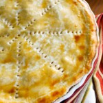 Pastel de polvorosa de pollo horneado en un refractario blanco.