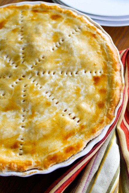 Pastel de polvorosa de pollo horneado en un refractario blanco.