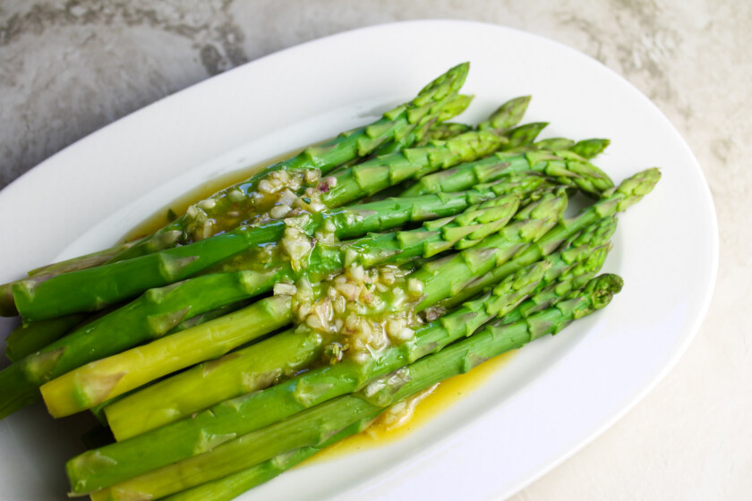 Vinaigrette-Asparagus-by-enrilemoine-5 Espárragos con vinagre de chalotas sobre un plato ovalado blanco.