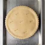 Polvorosa de atún sin hornear en una bandeja para hornear de metal, con agujeros para un tenedor en el centro, sobre una encimera de mármol.