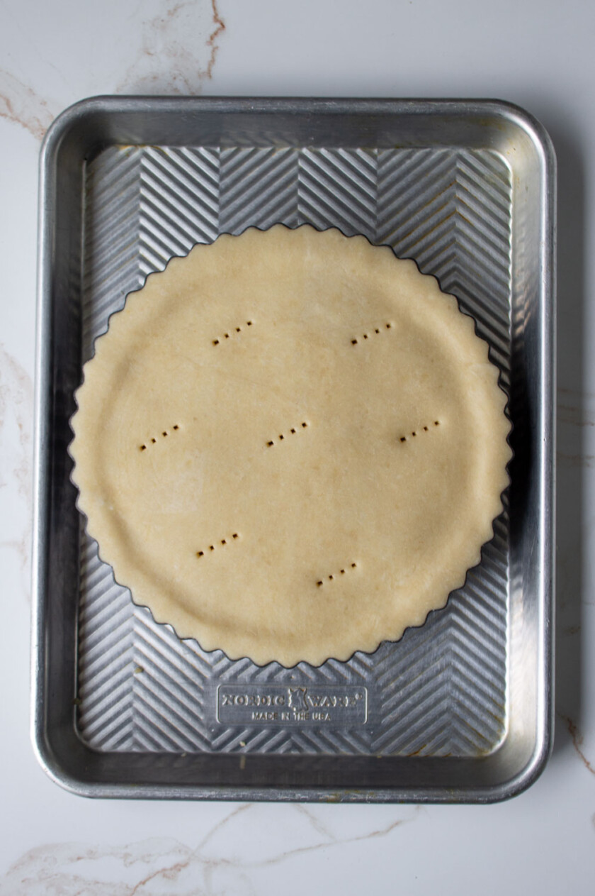 An uncooked covered pie on a tray.