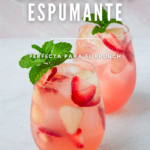 Dos vasos de sangría rosada con fresas y decorados con una ramita de menta.
