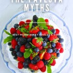 A pavlova topped with mixed berries and mint leaves on a decorative plate, with the text "DEBUNKING THE PAVLOVA MYTHS" and "BEST MIXED BERRY PAVLOVA EVER" overlaid on the image.