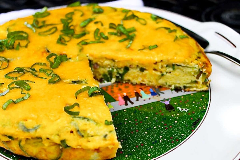 Una frittata de calabacín cortada, en un plato de servir.