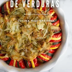 Un plato blanco redondo relleno con rodajas de calabacín, tomate y calabaza amarilla cuidadosamente dispuestas, cubierto con cebollas cocidas y hierbas. Perfecto para descubrir qué es un tian provenzal de verduras.