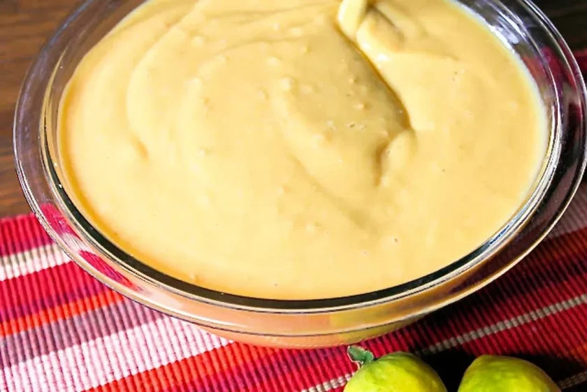 Un bol de cristal con puré de guayabas amarillas para hacer mermelada de guayaba.