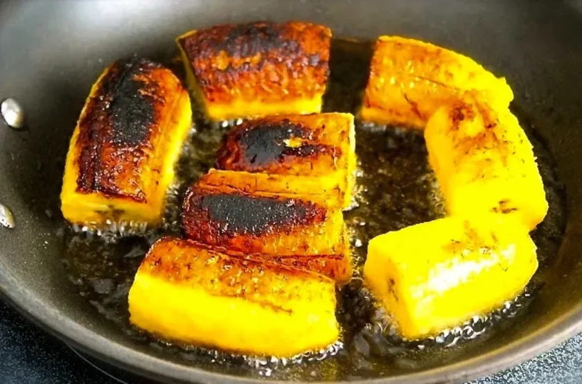 Plantain pieces being fried on a skillet.