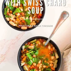 Two bowls of Cannellini Minestrone with Swiss chard, tomatoes, and a spoon in each bowl rest on a light surface.