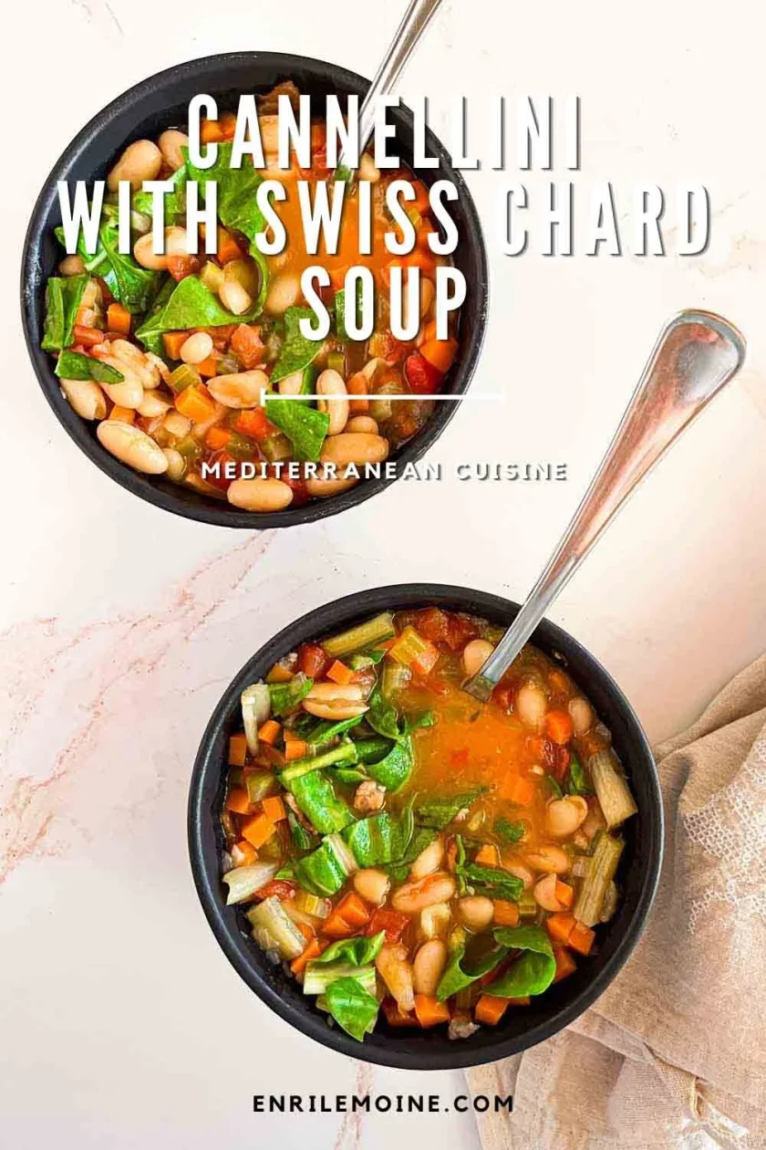 Two bowls of Cannellini Minestrone with Swiss chard, tomatoes, and a spoon in each bowl rest on a light surface.