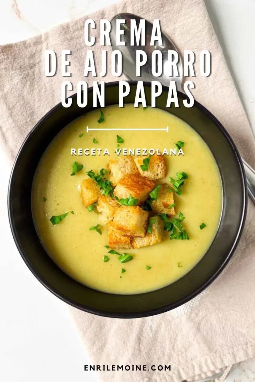 Un cuenco de crema de puerro y patata con picatostes y perejil, sobre una servilleta beige.